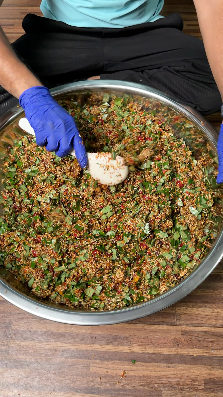 Mukhwas being mixed by hand in a steel bowl